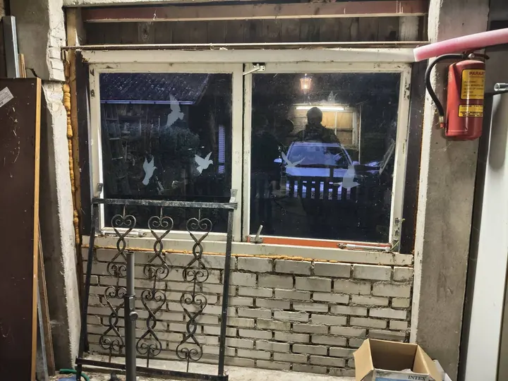 De garagewand voor de klus, met het oude raam