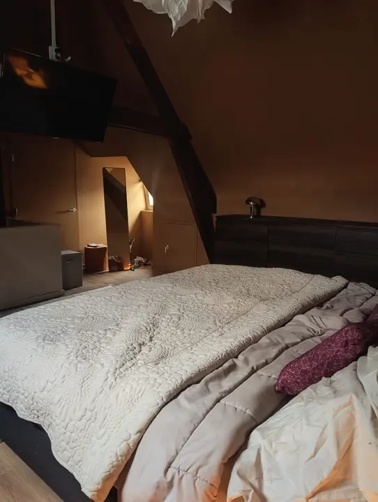 Slaapkamer op zolder met houten balken